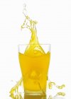 Nahaufnahme von Orangensaft, der aus einem Glas spritzt — Stockfoto