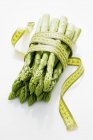 Green asparagus with tape measure — Stock Photo