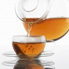 Verser le thé dans une tasse en verre — Photo de stock