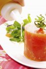 Parfait de tomate con ensalada y aderezo en plato blanco - foto de stock