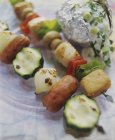 Deux kebabs : saucisse, poulet et légumes sur plaque de marbre — Photo de stock
