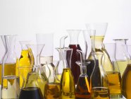 Vari tipi di olio in diversi recipienti di vetro — Foto stock