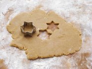 Elevated view of biscuit dough with star-shaped cookie cutter — Stock Photo
