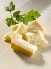 Parmesan with parsley on white — Stock Photo
