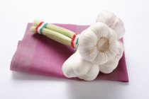 Garlic bulbs on pink napkin — Stock Photo