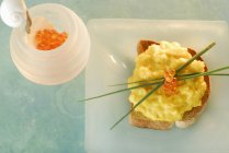 Huevo, caviar de salmón y cebollino en tostadas - foto de stock