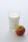 Glass of milk and an apple — Stock Photo
