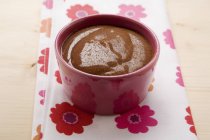 Closeup view of chocolate cream in bowl on towel — Stock Photo