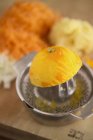 Meia laranja no espremedor de frutas cítricas — Fotografia de Stock