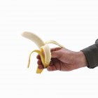 Mano che tiene mezzo sbucciato banana — Foto stock