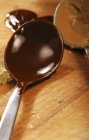 Vista de primer plano de la cobertura de chocolate negro en cuchara - foto de stock