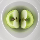 Manzana verde a la mitad - foto de stock