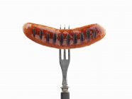 Grilled sausage on fork — Stock Photo