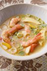 Closeup view of Asian prawn soup with vegetables and herbs — Stock Photo