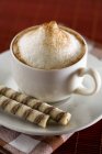 Cappuccino with wafer rolls — Stock Photo