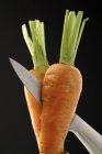 Cutting carrot in half — Stock Photo
