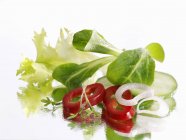Salade mixte posée sur une surface blanche — Photo de stock