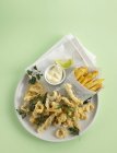 Fried calamari with coriander and fried chips — Stock Photo