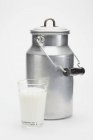 Lattina di latte e un bicchiere di latte — Foto stock