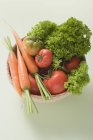 Морковь и салат в маленькой корзине — стоковое фото