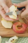 Женские руки Разрезая яблоко на четвертаки — стоковое фото