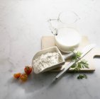 Jug of milk and scoop of flour — Stock Photo