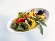 Closeup view of marinated peppers with olives — Stock Photo