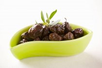 Piatto giallo di olive nere — Foto stock
