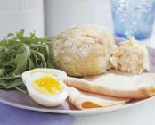 Jamón con huevo cocido y panecillo - foto de stock