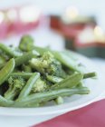 Blanchiertes grünes Gemüse auf weißem Teller — Stockfoto