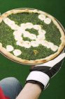 Пицца со шпинатом и футбольным декором — стоковое фото