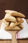 Closeup view of triangular sweet puff pasties in pile on wooden server — Stock Photo