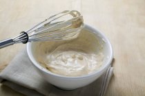 Closeup view of whisk over batter in bowl — Stock Photo