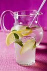 Lemonade in glass and jug — Stock Photo