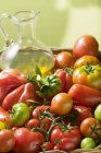 Tomatoes and jug of olive oil — Stock Photo