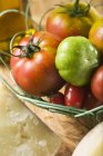 Tomatoes in wire basket — Stock Photo