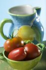 Tomatoes in green bowl — Stock Photo