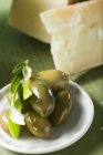 Зеленые оливки с веточкой на тарелке — стоковое фото