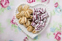 Süßigkeiten auf herzförmigem Teller — Stockfoto