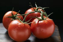 Четыре помидора на лозе — стоковое фото