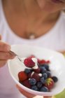 Frau isst Beeren mit Joghurt — Stockfoto