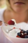 Woman eating berries with yoghurt — Stock Photo