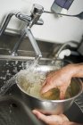 Cropped view of hands soaking gelatine in water — Stock Photo