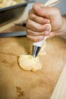 Cropped view of person decorating Choux pastry with cream — Stock Photo