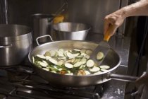 Turning courgette slices in frying pan — Stock Photo