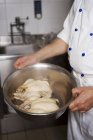 Обрізаний вид шеф-кухаря, що несе миску з двома сирими курчатами — стокове фото