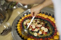Primo piano vista ritagliata di persona versando gelatina sulla frutta fresca — Foto stock