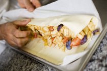 Closeup cropped view of man rolling fruit strudel — Stock Photo