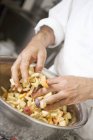 Closeup cropped view of person mixing fruit with bread crumbs — Stock Photo