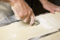 Cook cutting raw pasta tough — стоковое фото